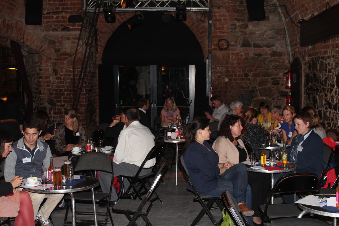Participants of the network meeting sit at different table circles on one evening and talk to each other